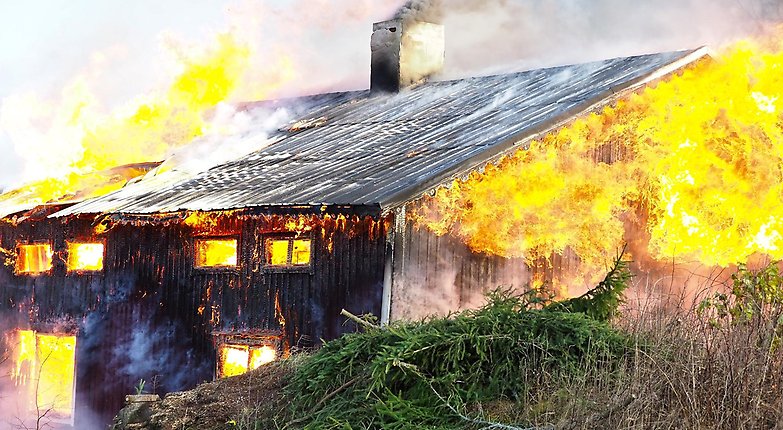 Bild på ett hus som är övertänt, brinner för fullt.